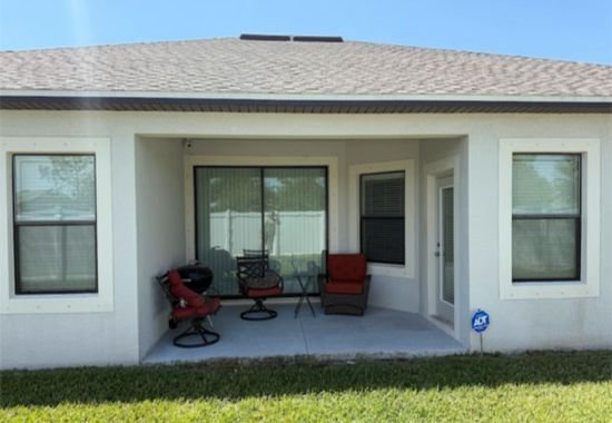 Exterior house wall and patio before cleaning, showing dirt buildup.
